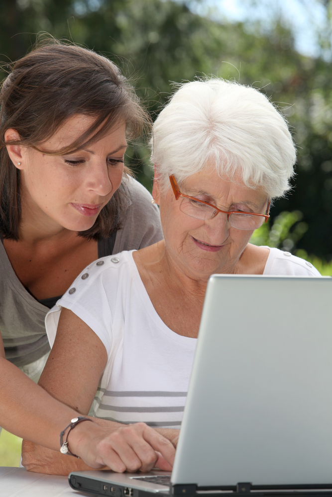 Assistant teaching senior woman computer shutterstock_58997185 Senior using computer